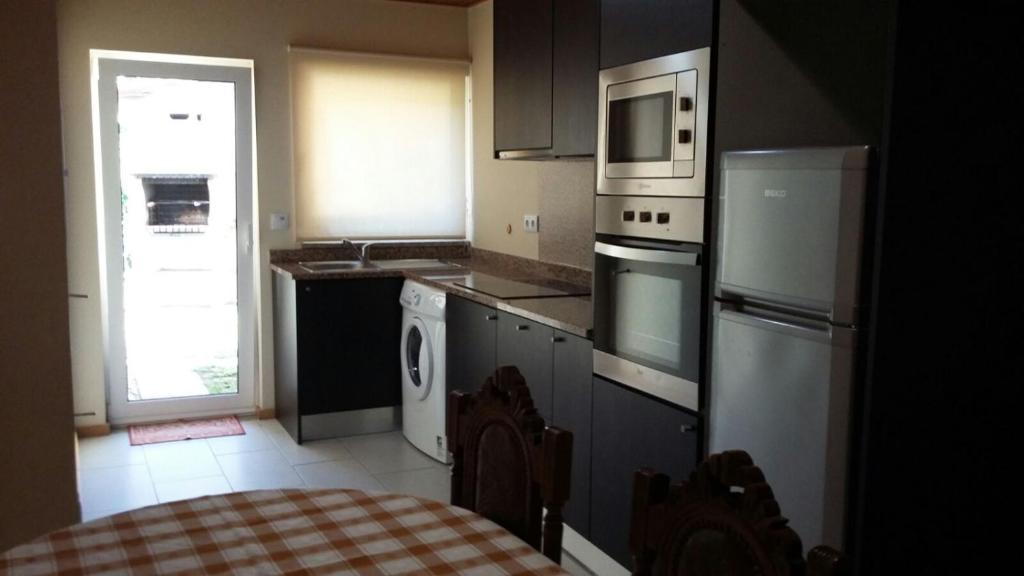 a kitchen with stainless steel appliances and a window at Cantinho Cruzeiro in Vieira do Minho