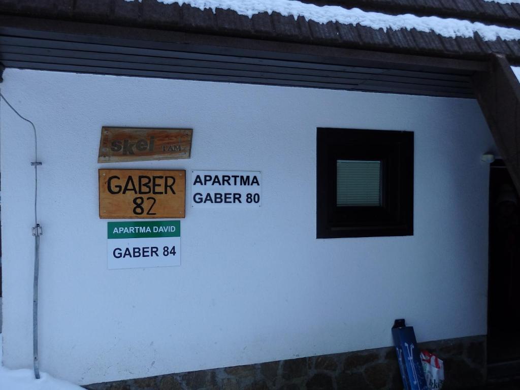 un mur blanc avec des panneaux indiquant la rue dans l'établissement Apartma Gaber 80, à Zreče
