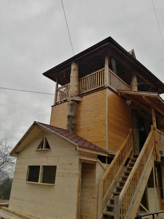 a large wooden house with a wrap around deck at Tree House in Sofia