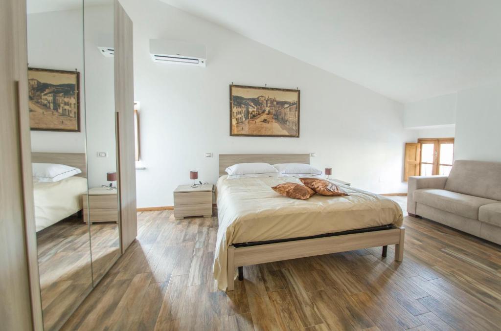 San Martino al CiminoにあるB&B Locanda Cistercenseのベッドルーム(ベッド1台、ソファ、鏡付)