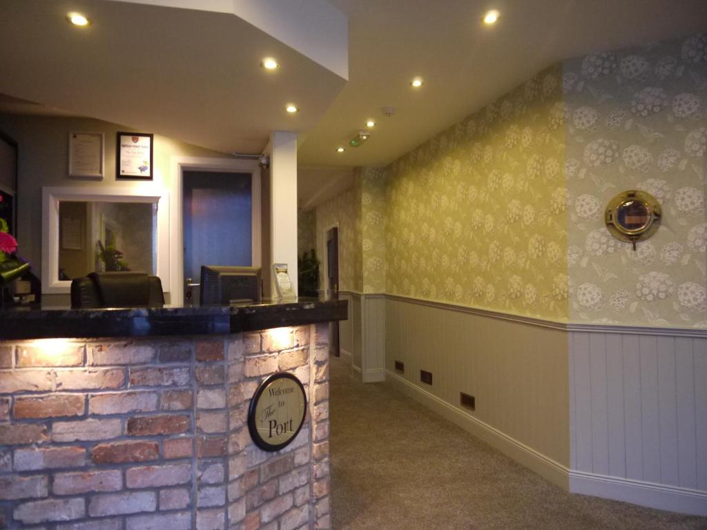 a lobby with a brick wall with a clock on it at The Port Hotel in Portrush