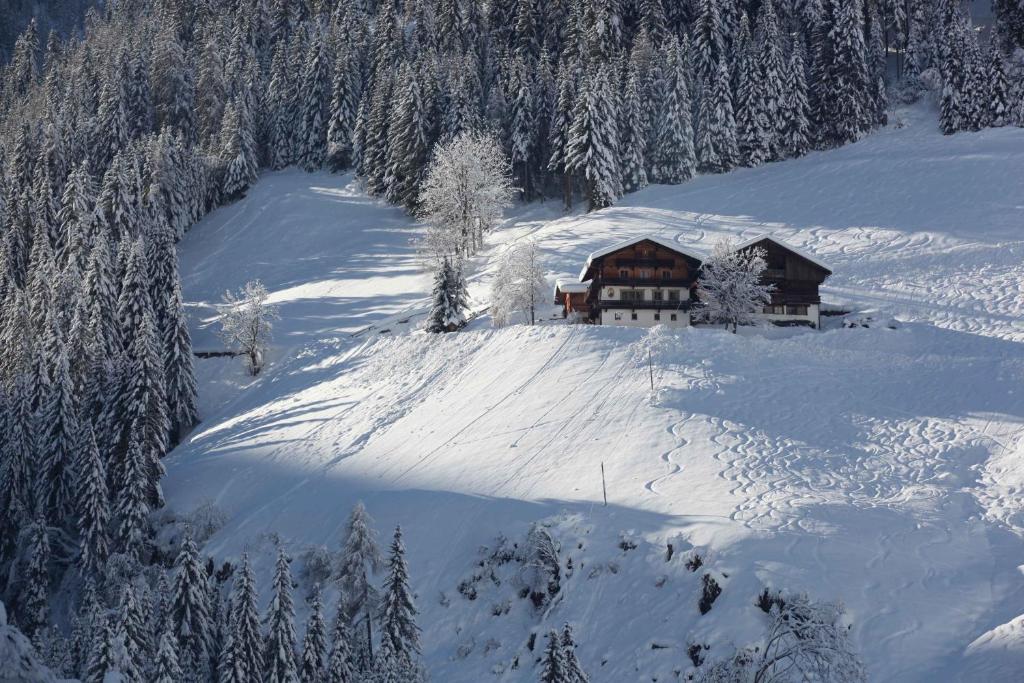 a house on a snow covered hill with trees at Walcheggerhof in Innervillgraten