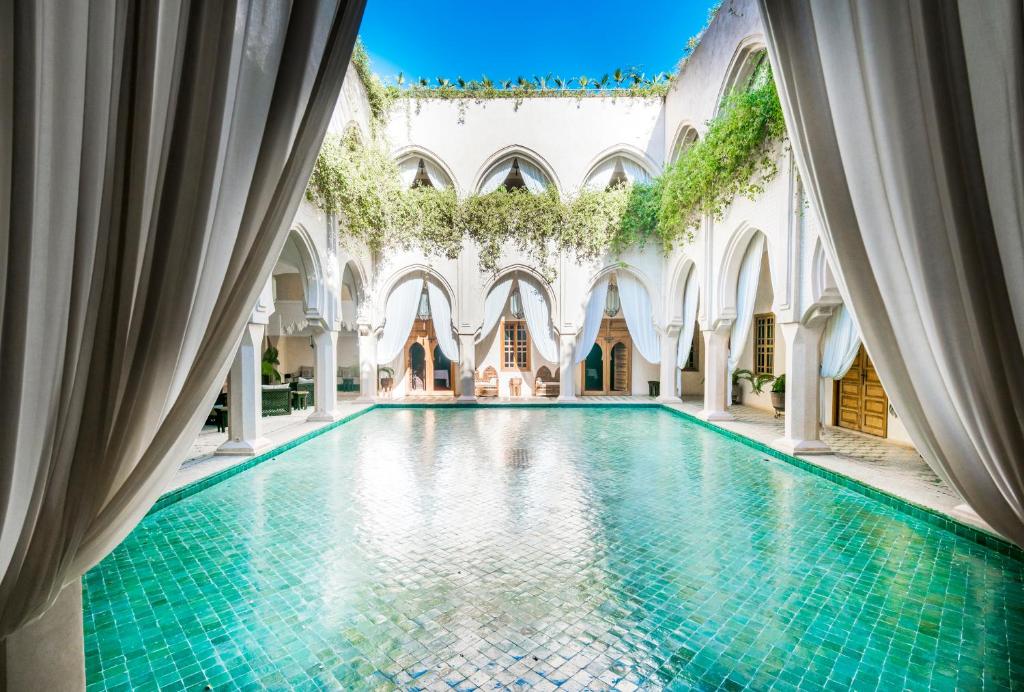 uma piscina interior num edifício com piso em azulejo em Almaha Marrakech Restaurant & SPA em Marrakech