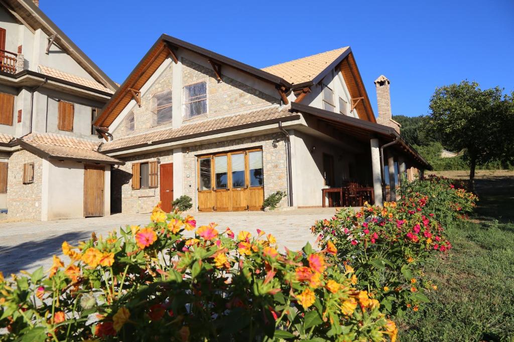 une maison avec des fleurs devant elle dans l'établissement Agriturismo Pirara, à SantʼAngelo