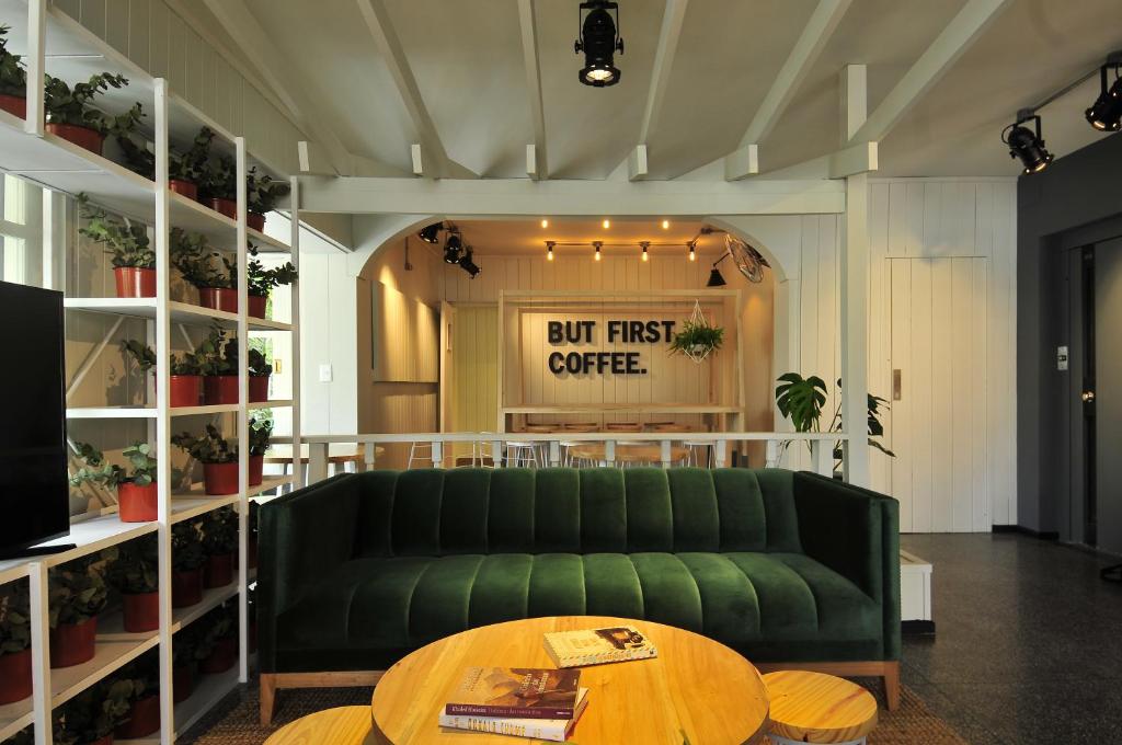プンタ・デル・エステにあるHotel Dollarのコーヒーテーブル付きの客室で、緑のソファが備わります。