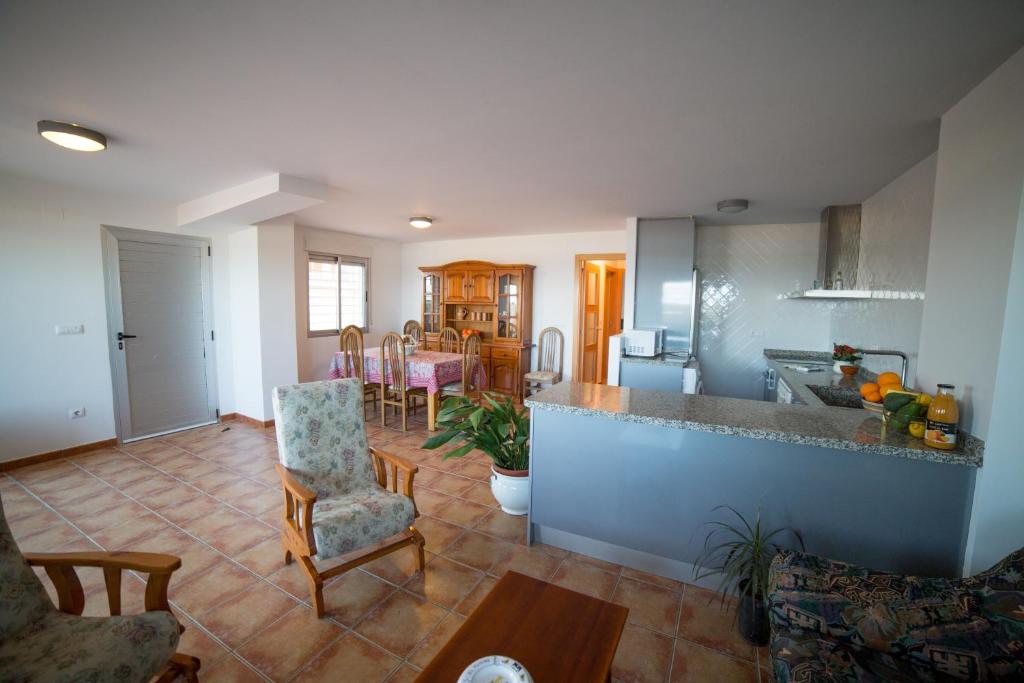 cocina y sala de estar con mesa y sillas en Apartamento Voramar, en Daimuz