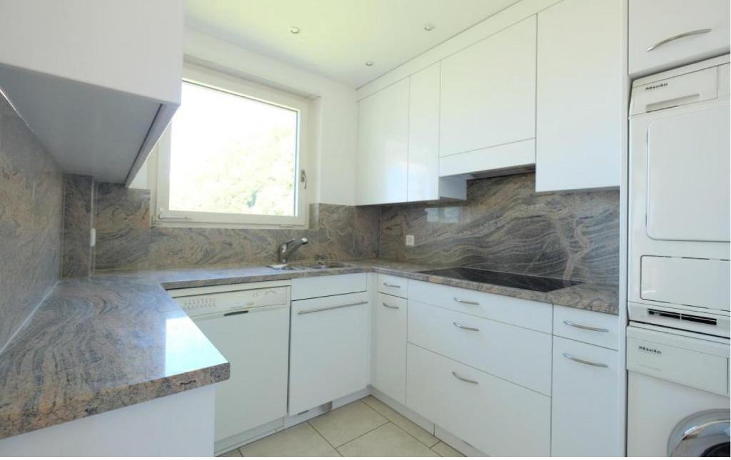 a white kitchen with white cabinets and a window at Vaduz Zentrum Meierhof in Vaduz