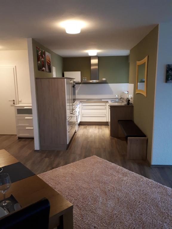 eine große Küche mit weißen Schränken und einem Tisch in der Unterkunft Deluxapartment in Kaiserslautern