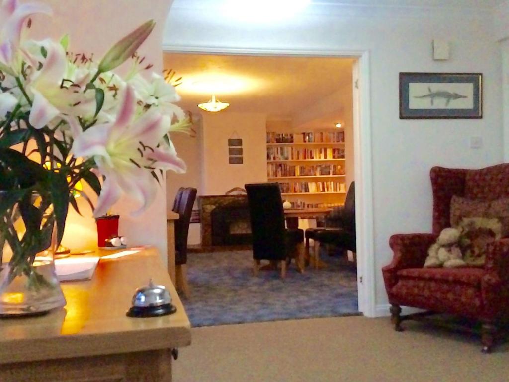 a living room with a vase of flowers on a table at Wellingtons in Fowey