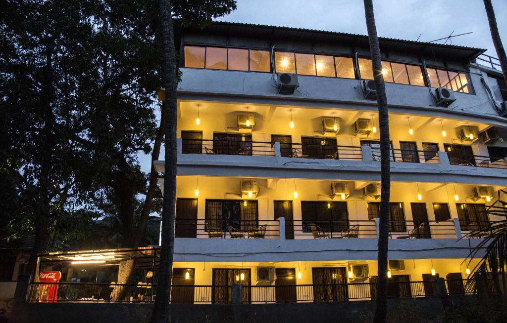 a large white building with lights on at Hotel Arambol Arbour in Arambol