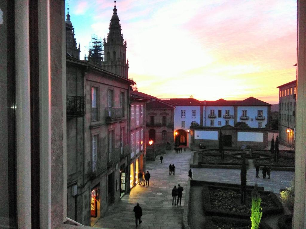 a view from a window of a city street at sunset at Apartamentos Casa de La Inmaculada in Santiago de Compostela