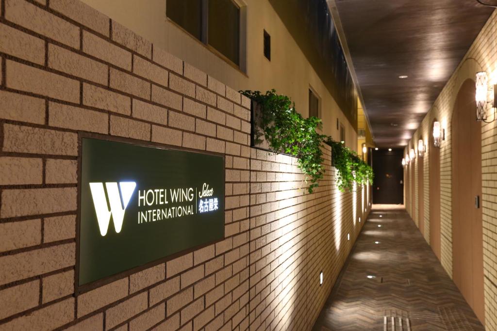 名古屋市にあるホテル ウィング インターナショナル セレクト 名古屋 栄の煉瓦壁の看板付廊