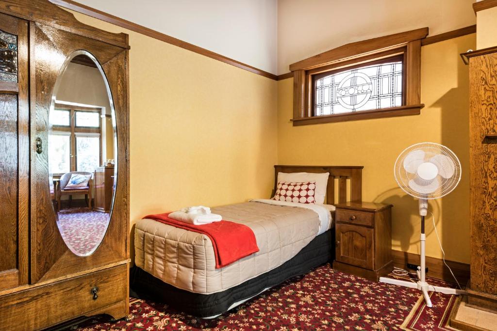 a bedroom with a bed and a mirror at Halswell Lodge in Wellington