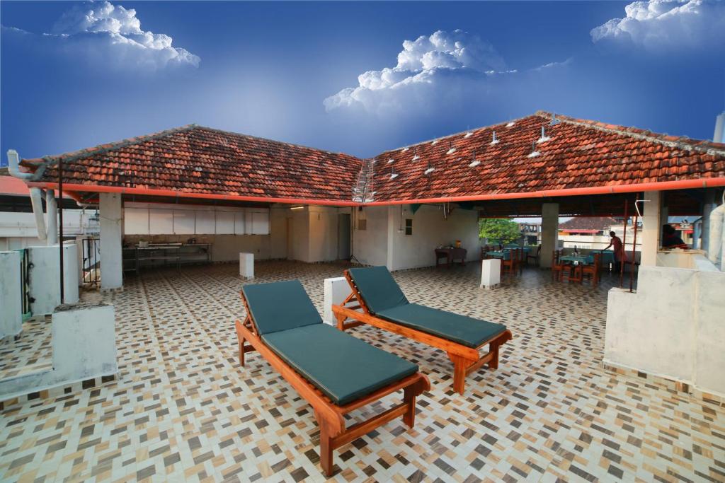 a patio with two lounge chairs and a roof at La Lune Fort Kochi in Cochin