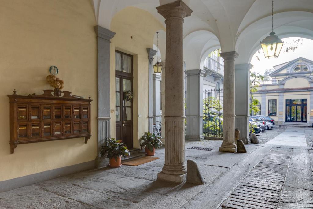 una galería con columnas y un edificio con coches en Acadamis - Apartment Cleopatra, en Turín