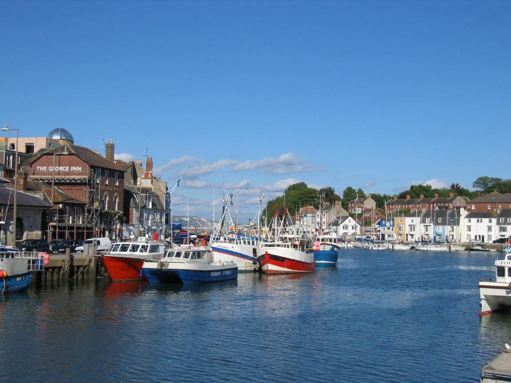 a group of boats are docked in a harbor at The Crown Hotel in Weymouth