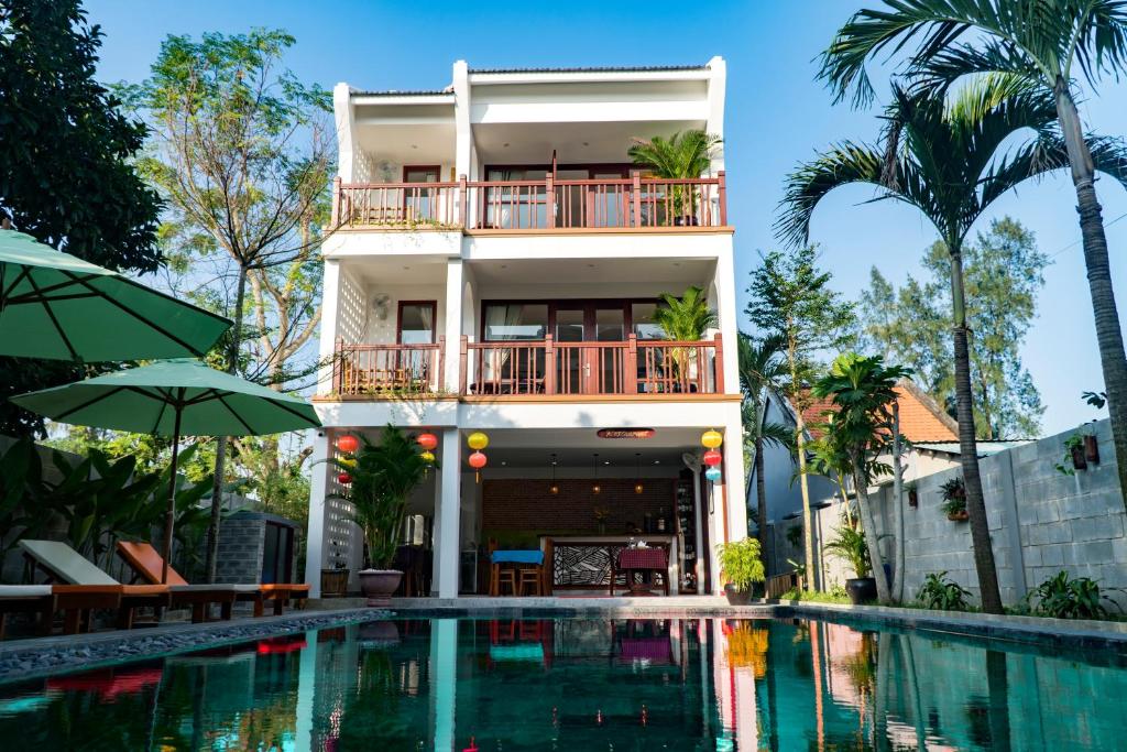 uma casa com piscina em frente a um edifício em Louis Villa Hoi An em Hoi An