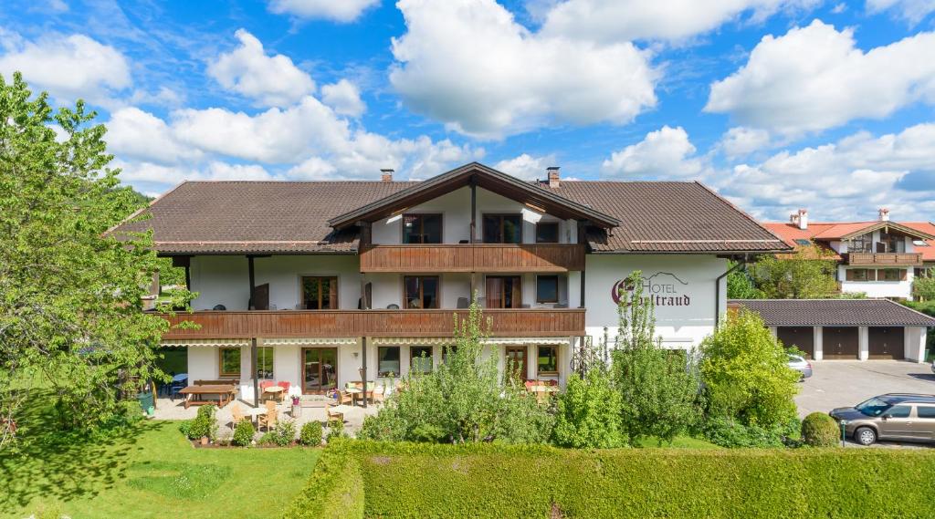 a building with a car parked in a parking lot at Kleines Hotel Edeltraud in Aschau im Chiemgau