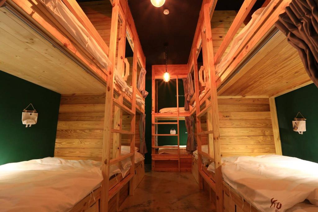 two bunk beds in a room with wooden walls at Kenting Original Hostel in Kenting