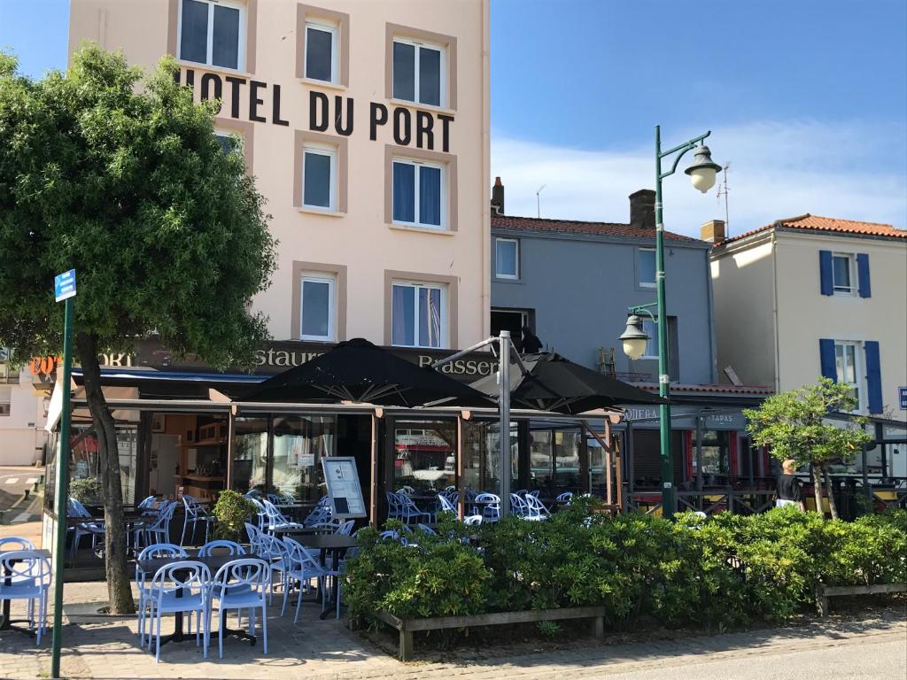 un port avec des tables et des chaises devant un bâtiment dans l'établissement Hôtel Du Port, à Les Sables-dʼOlonne