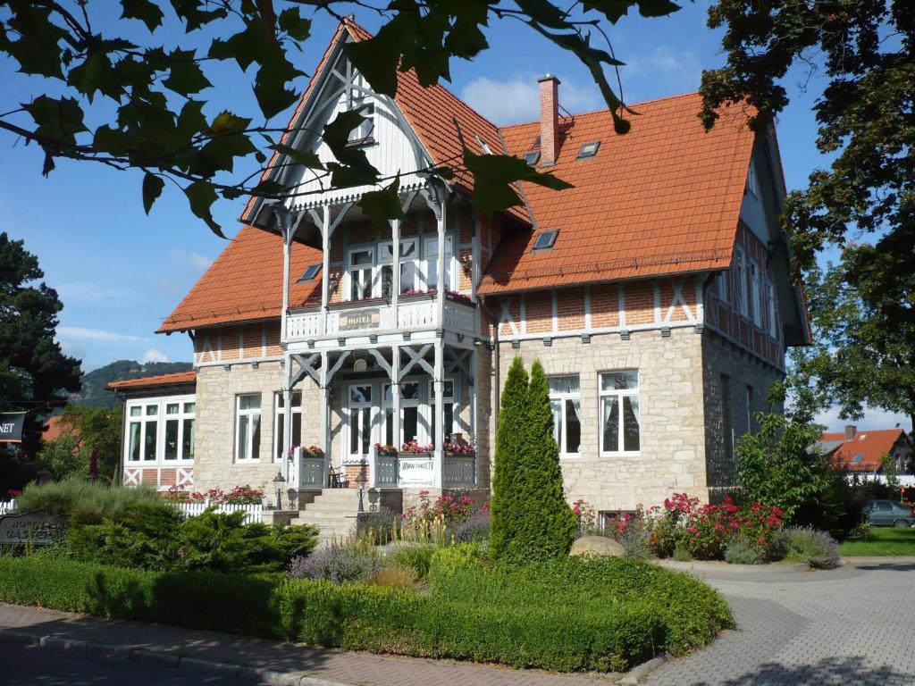 une grande maison avec un toit orange dans l'établissement Gästehaus Musestieg, à Thale