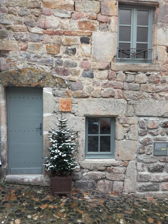 a christmas tree in front of a stone building at Gîte du Besset in Pradelles
