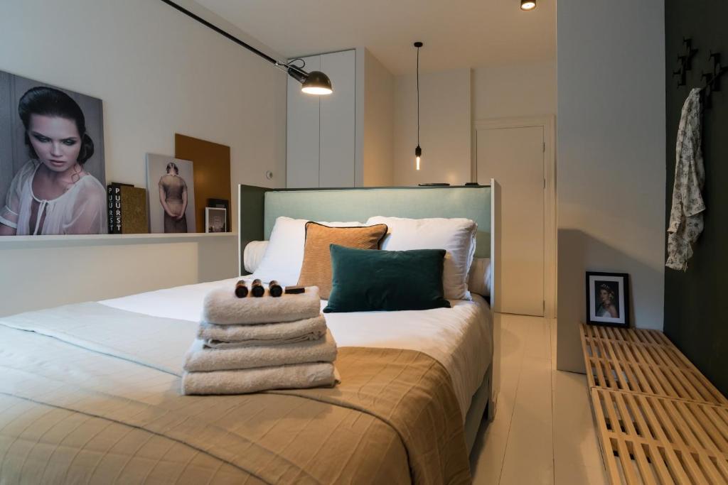 Canal Suite City Centre في أمستردام: غرفة نوم عليها سرير وفوط