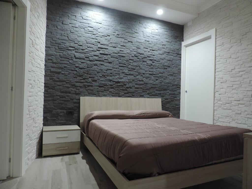 una camera con letto e muro di mattoni di La Casetta a Leporano