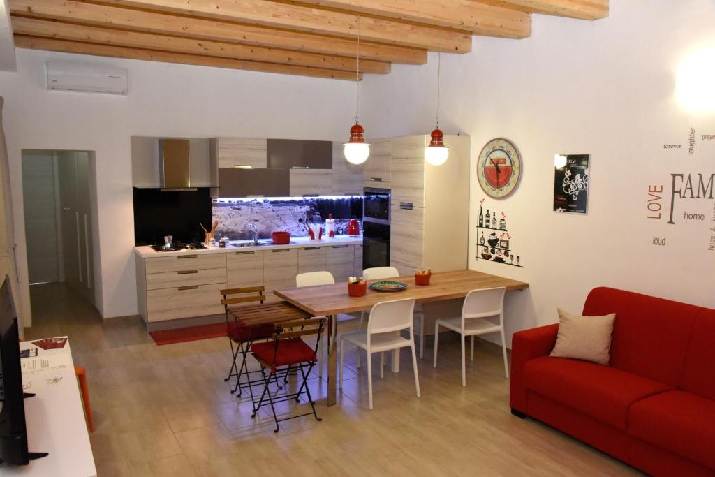 a living room with a table and a red couch at Casa Mia in Siracusa