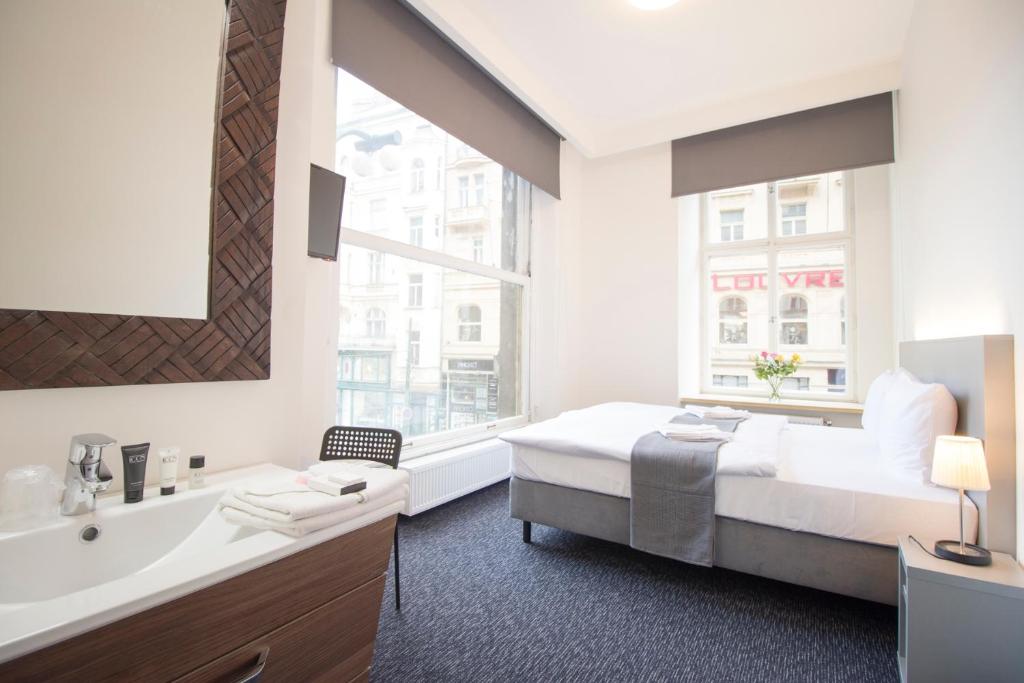 1 dormitorio con cama, bañera y lavamanos en Narodni Stay, en Praga