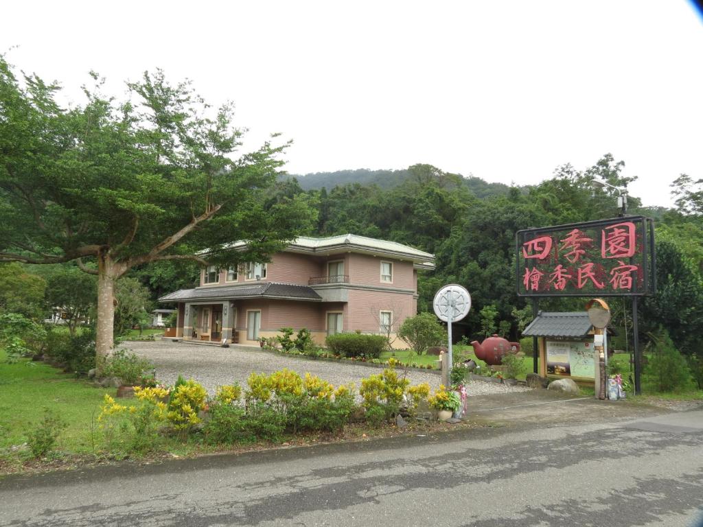 a pink house with a sign in front of it at Seasons Inn in Jiaoxi