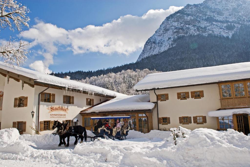 a horse drawn carriage in the snow in front of a building at Hotel-Gasthof Mauthäusl in Weißbach