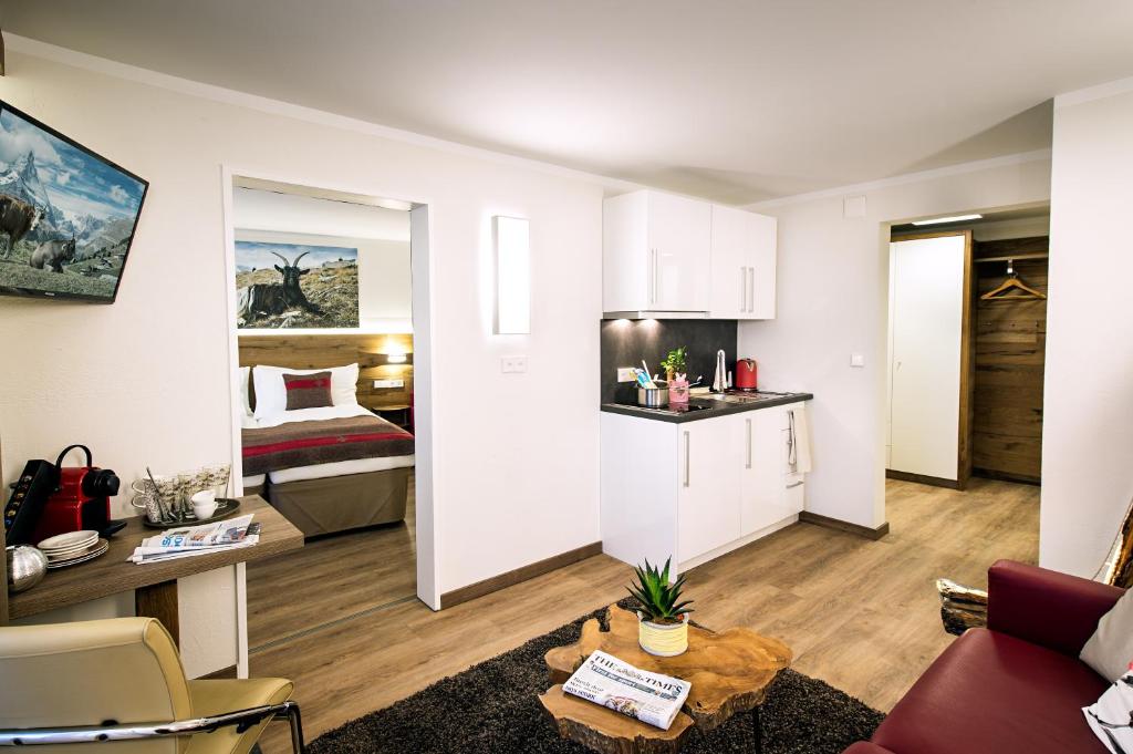 un soggiorno con divano e una camera con letto di B-Inn Apartments Zermatt a Zermatt