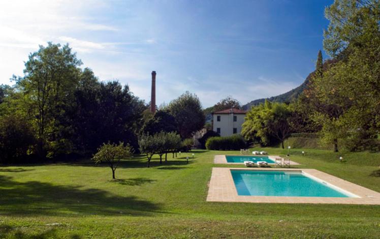 a yard with a swimming pool and a house at Villa La Bianca in Camaiore