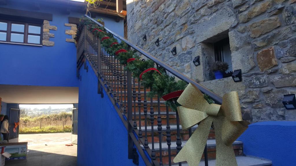 a staircase in a blue building with plants on it at Rodiles Rural Apartamentos in Selorio