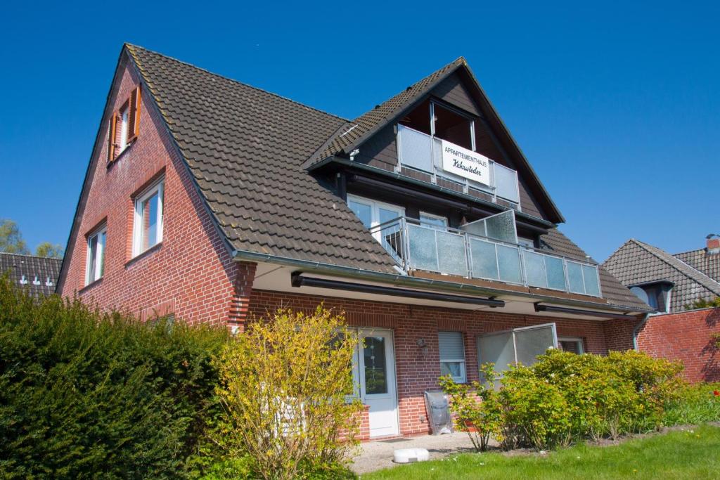 a house with a balcony on top of it at Appartmenthaus Kehrwieder in Sankt Peter-Ording