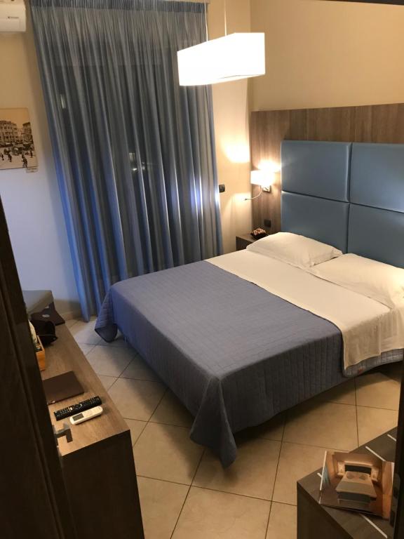 a bedroom with a bed and a blue curtain at Napoli Com'era in Naples