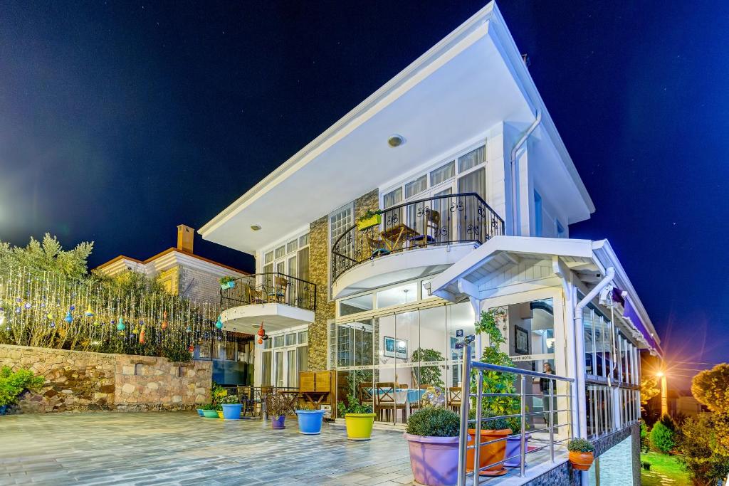 a large white building with potted plants in front of it at Nefes Hotel in Ayvalık