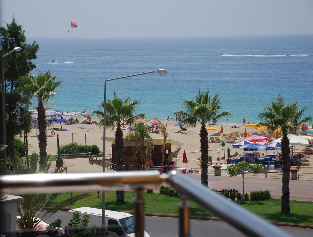 uma vista para uma praia com palmeiras e para o oceano em Kleopatra Ikiz Hotel em Alanya