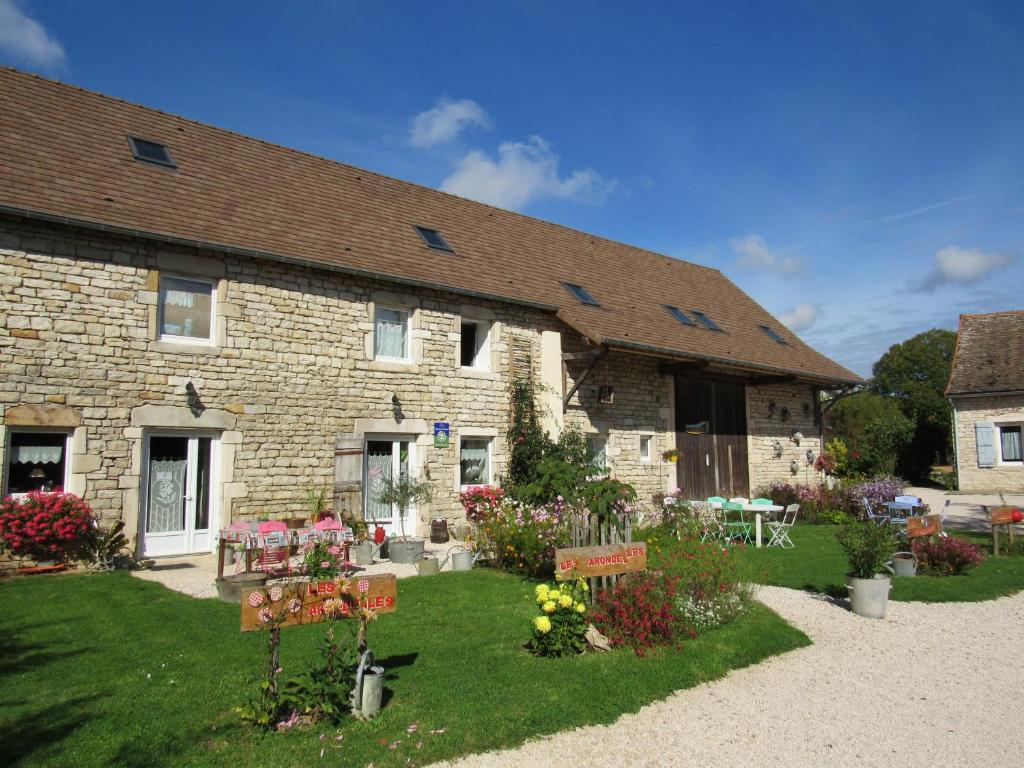 une maison en pierre avec un jardin en face dans l'établissement Chambres d'hôtes Les Arondelles, à Virey-le-Grand