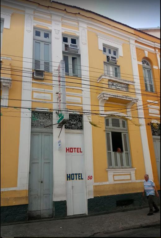 a man is standing in front of a building at Hotel Cabo Finisterra in Rio de Janeiro