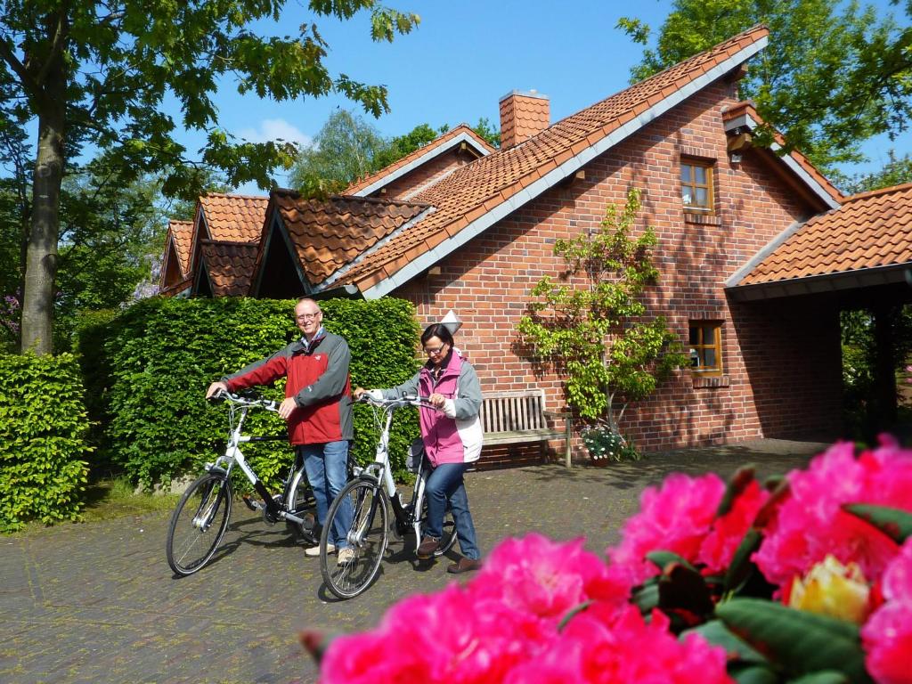 a man and woman standing with bikes in front of a house at BioDohrn in Bad Zwischenahn