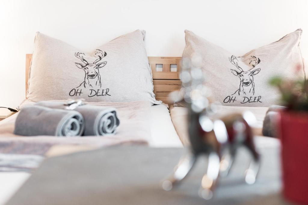 a bedroom with a bed with two deer pillows at Apartment Haus Gold in Fusch an der Glocknerstraße