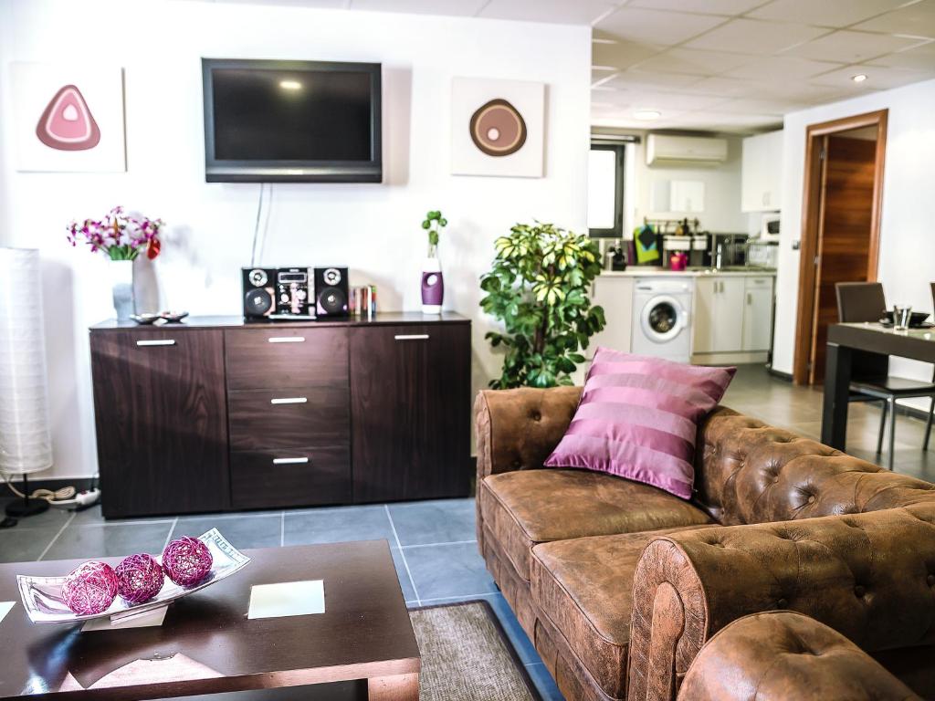ein Wohnzimmer mit einem Sofa und einem Tisch in der Unterkunft Apartamento ALDAMY in Granada