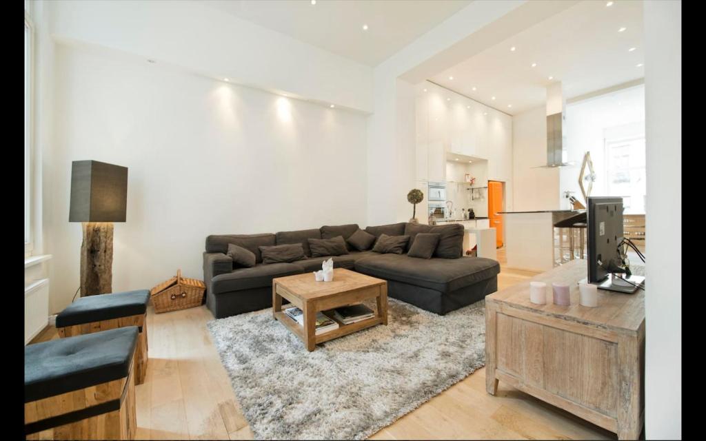 ein Wohnzimmer mit einem Sofa und einem Tisch in der Unterkunft Apartment Pacific - Duplex with Sauna in Antwerpen
