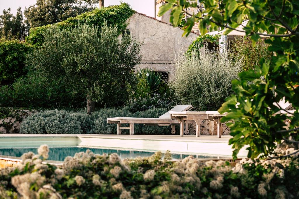 a pool with a picnic table and chairs next to a house at Holiday Home Stancija Srem in Belej