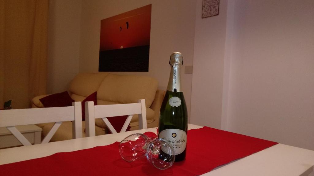 タリファにあるBonito, luminoso, cerca del mar con Parkingのワイングラス付きのテーブルに座ったワイン1本