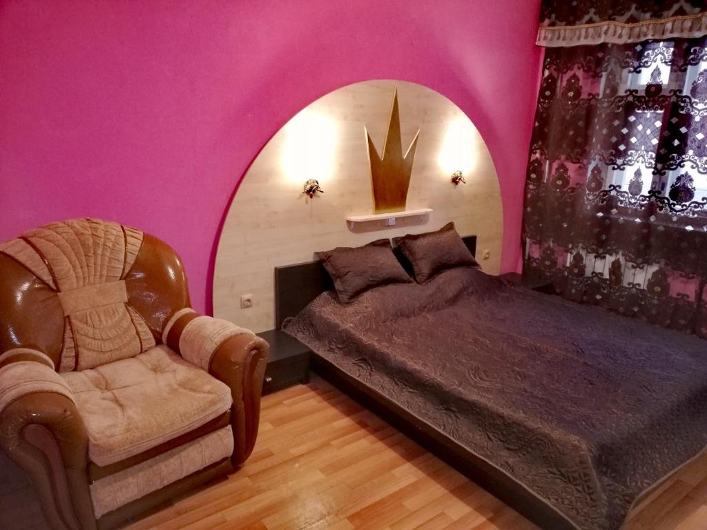 イヴァノヴォにあるApartments on Moskovskiy 12の紫の壁の客室で、ベッド1台と椅子1脚が備わります。