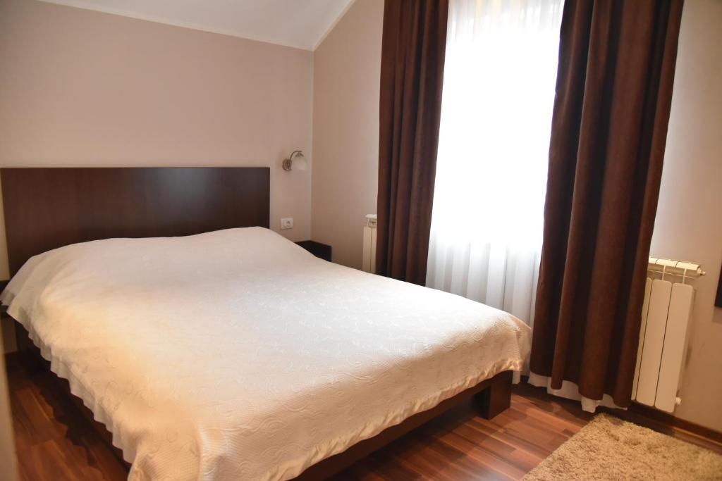 a bedroom with a white bed and a window at B&B Park in Sremčica
