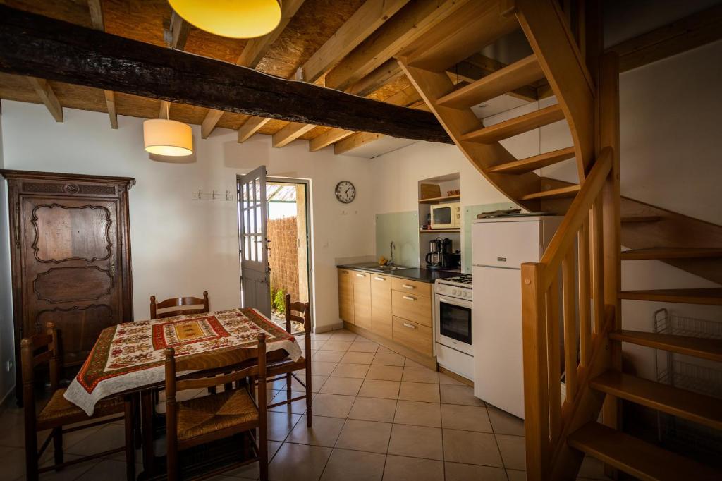 une cuisine avec une table et une cuisine avec un escalier dans l'établissement Les Fenals, à Fitou